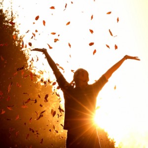 Woman playing with autumn leaves