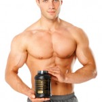 Muscular man holding container of training supplements