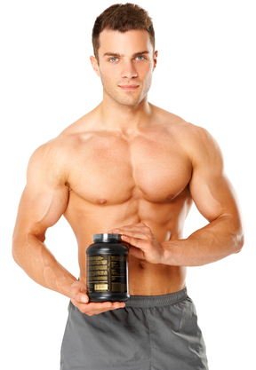 Muscular man holding container of training supplements